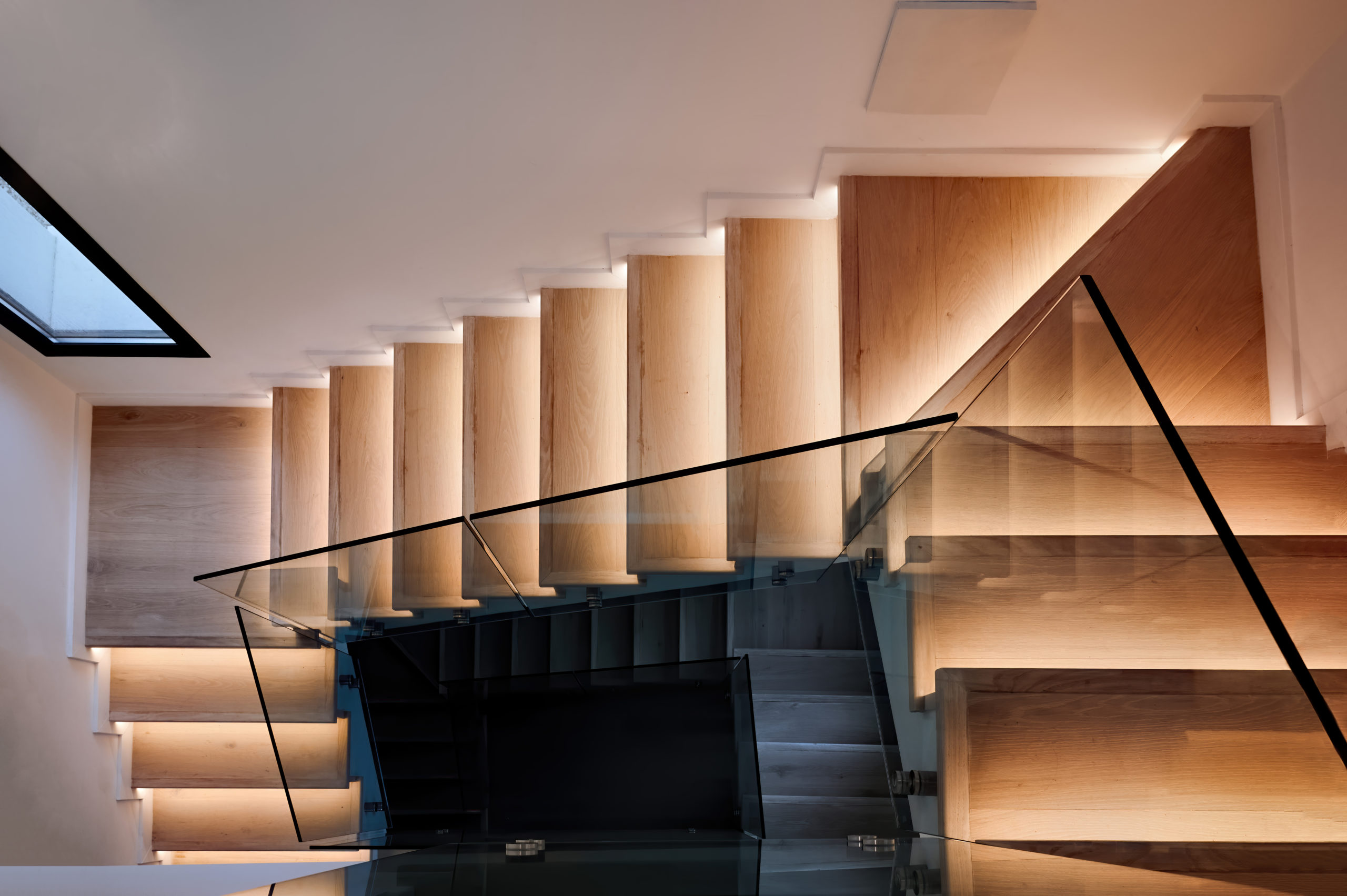 moderne trapp med lys i trinnene og glassrekkverk